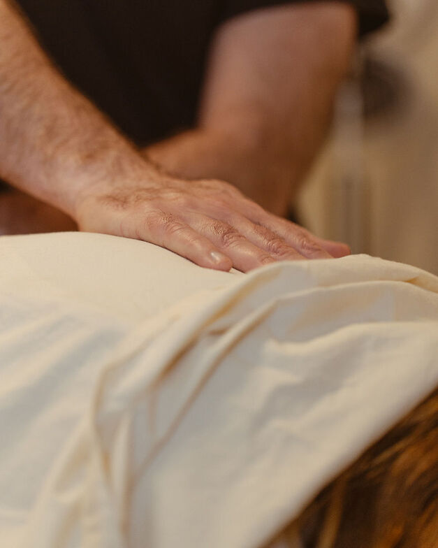 a person is massaging another persons back in a safe and affirming way to treat a chronic pain condition